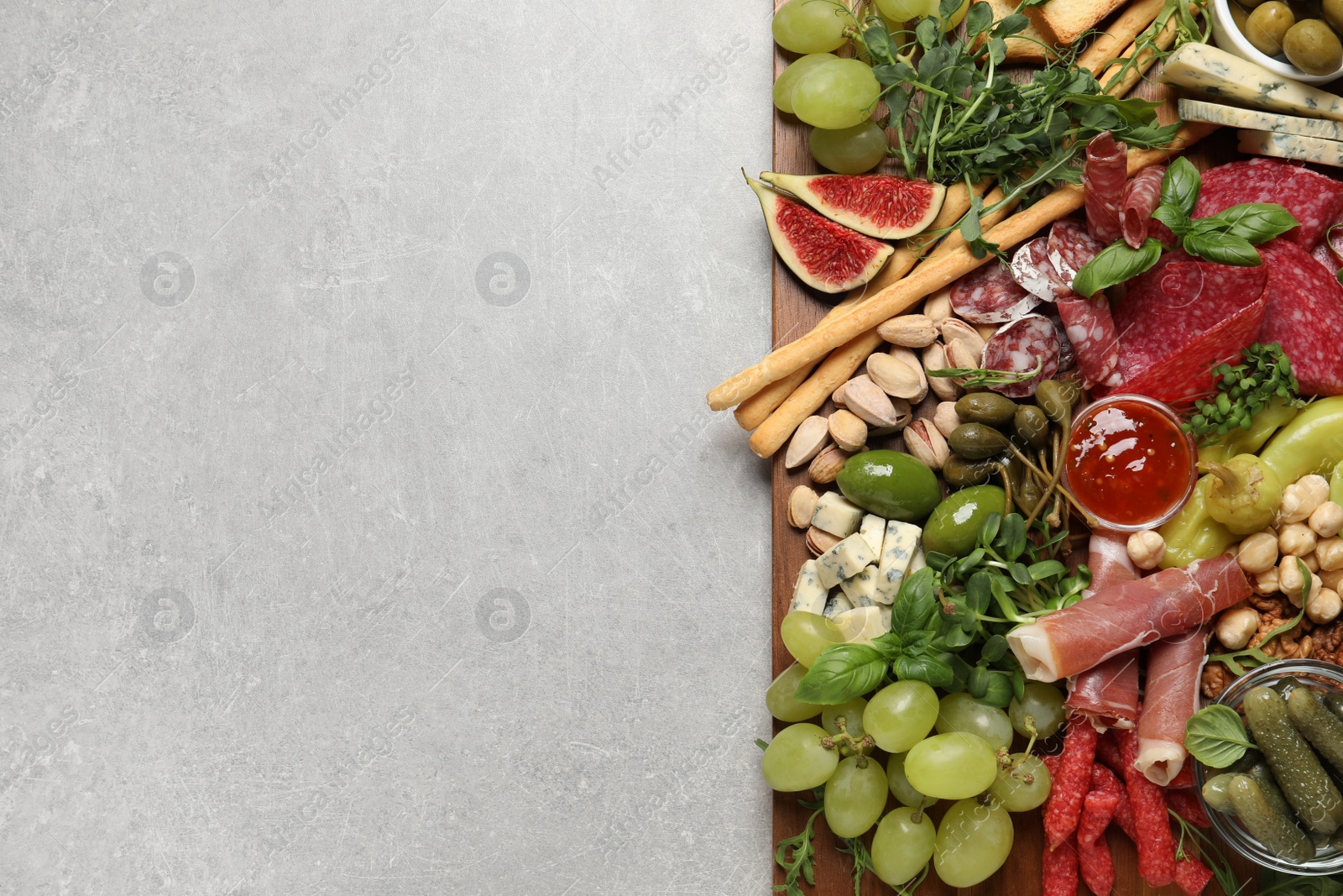 Photo of Set of different delicious appetizers served on light grey table, top view. Space for text