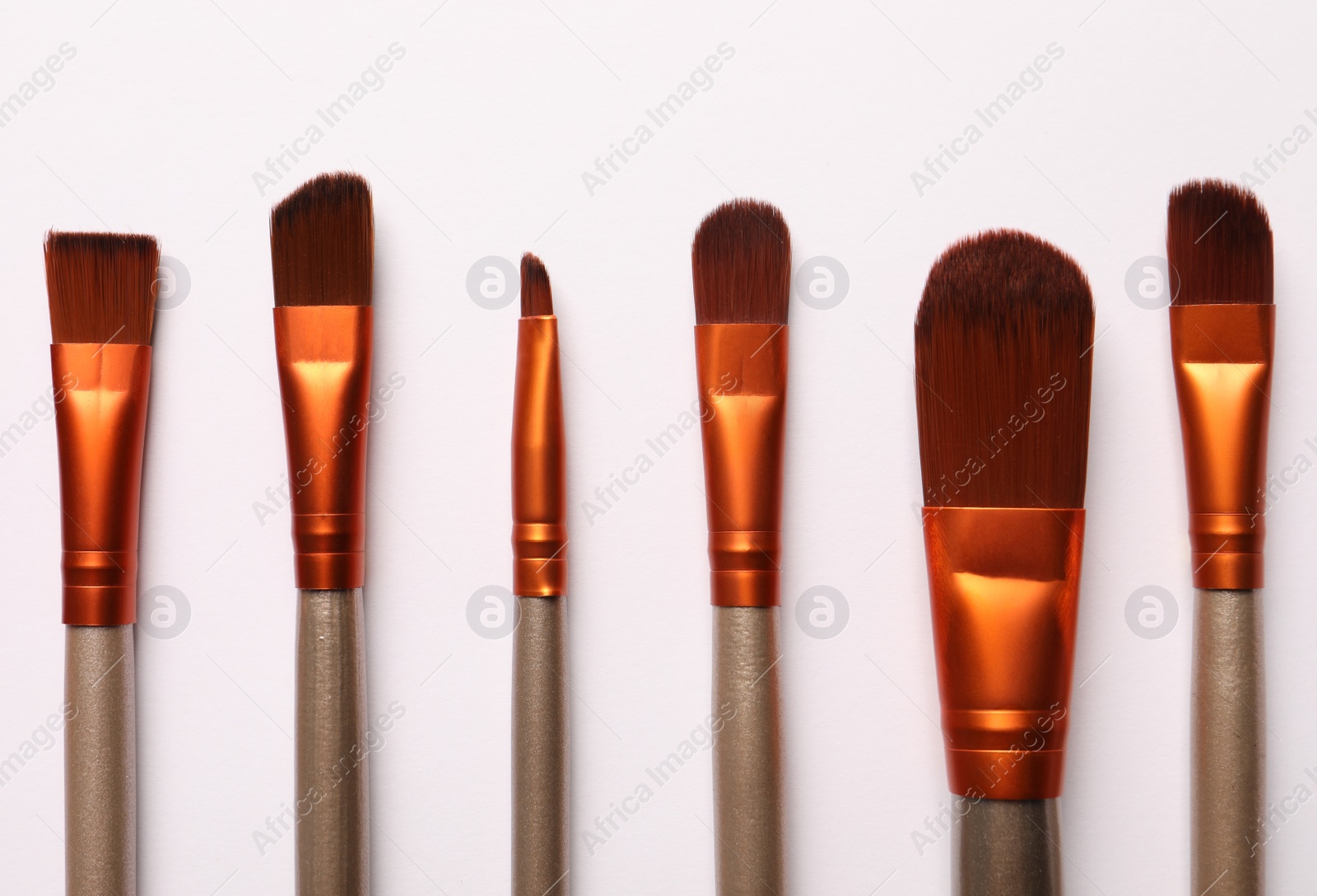 Photo of Different makeup brushes on white background, flat lay