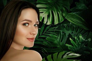 Image of Beautiful young woman and tropical leaves, closeup view with space for text. Spa portrait