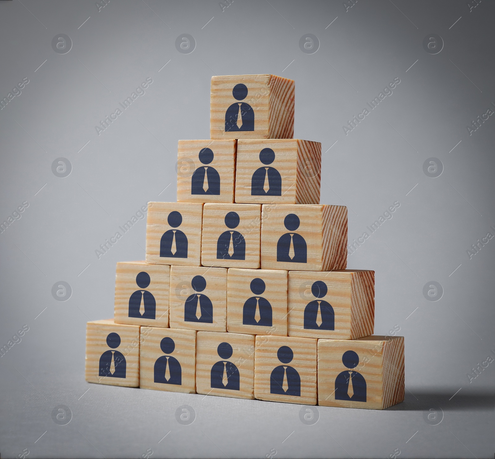 Image of Team and management concept. Pyramid of wooden cubes with human icons on grey background