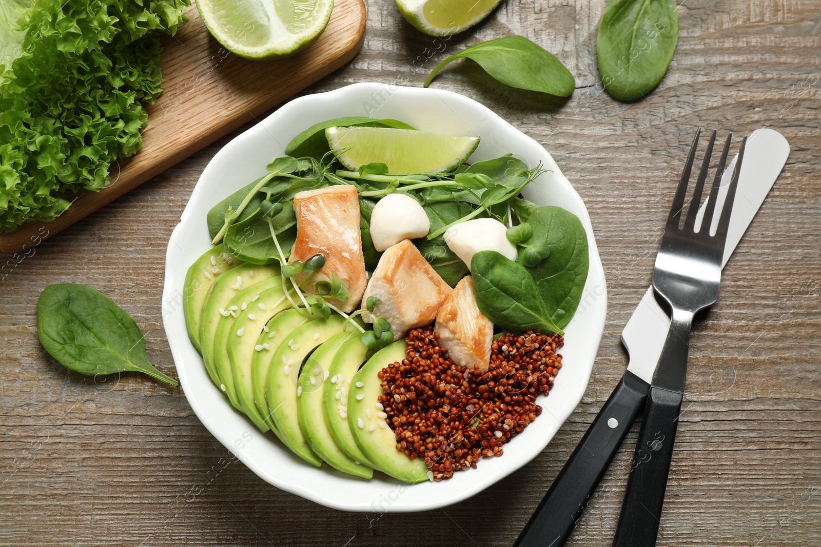 Photo of Delicious avocado salad with chicken on wooden table, flat lay