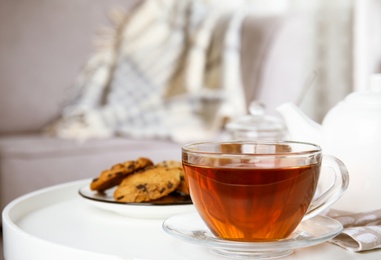 Photo of Cup of hot tea on white table indoors. Winter drink