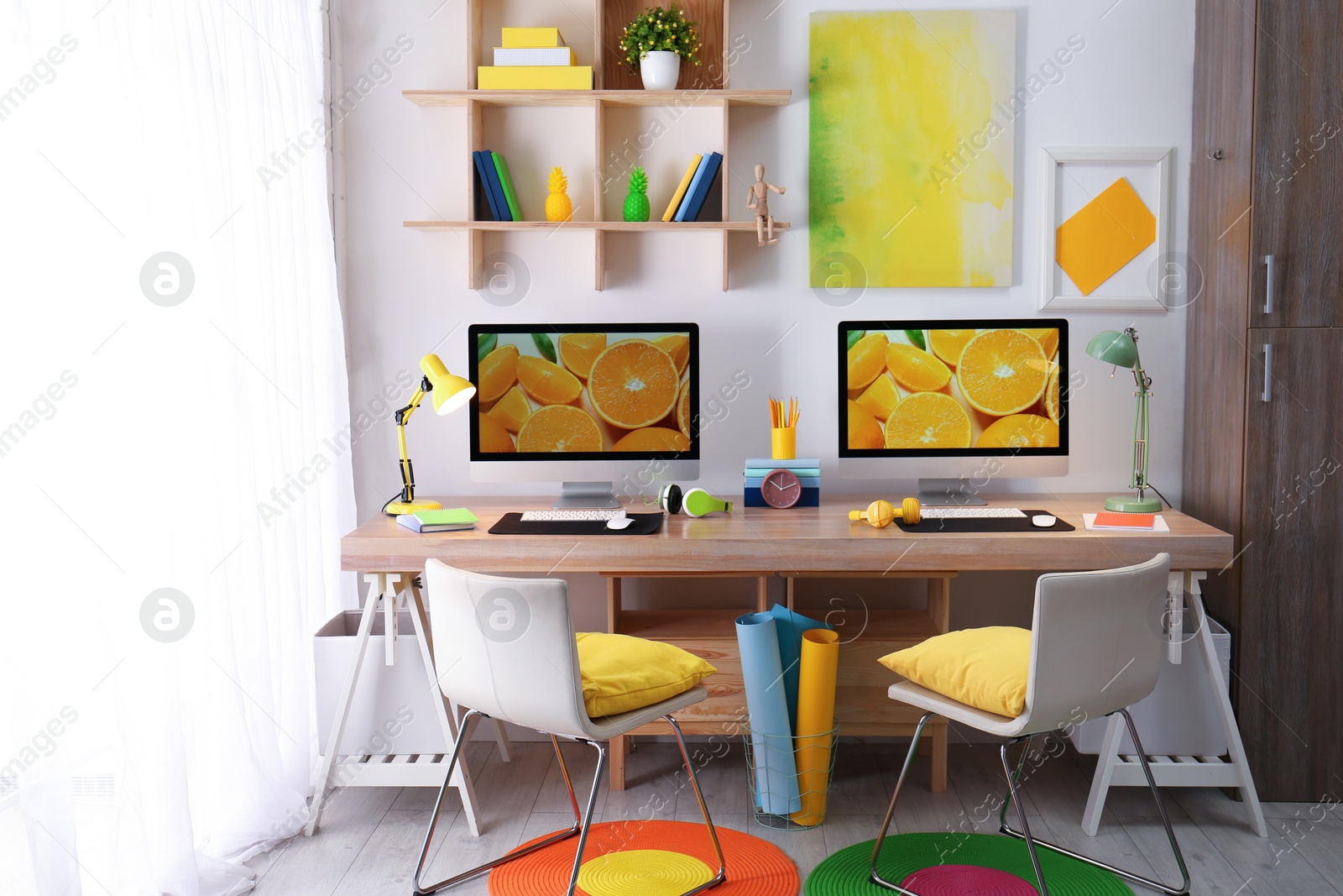 Photo of Modern workplace with large desk and computers in room. Stylish interior