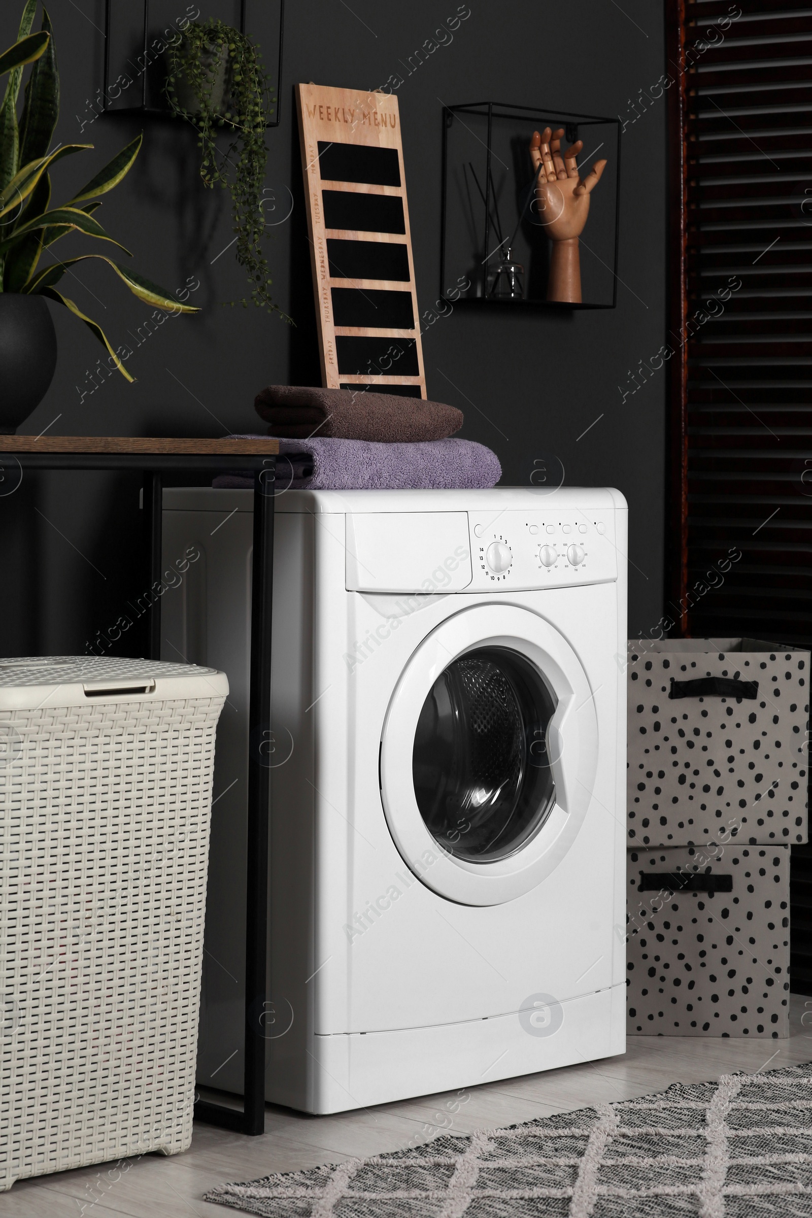 Photo of Stylish laundry room with washing machine. Interior design