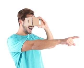 Photo of Young man using cardboard virtual reality headset, isolated on white