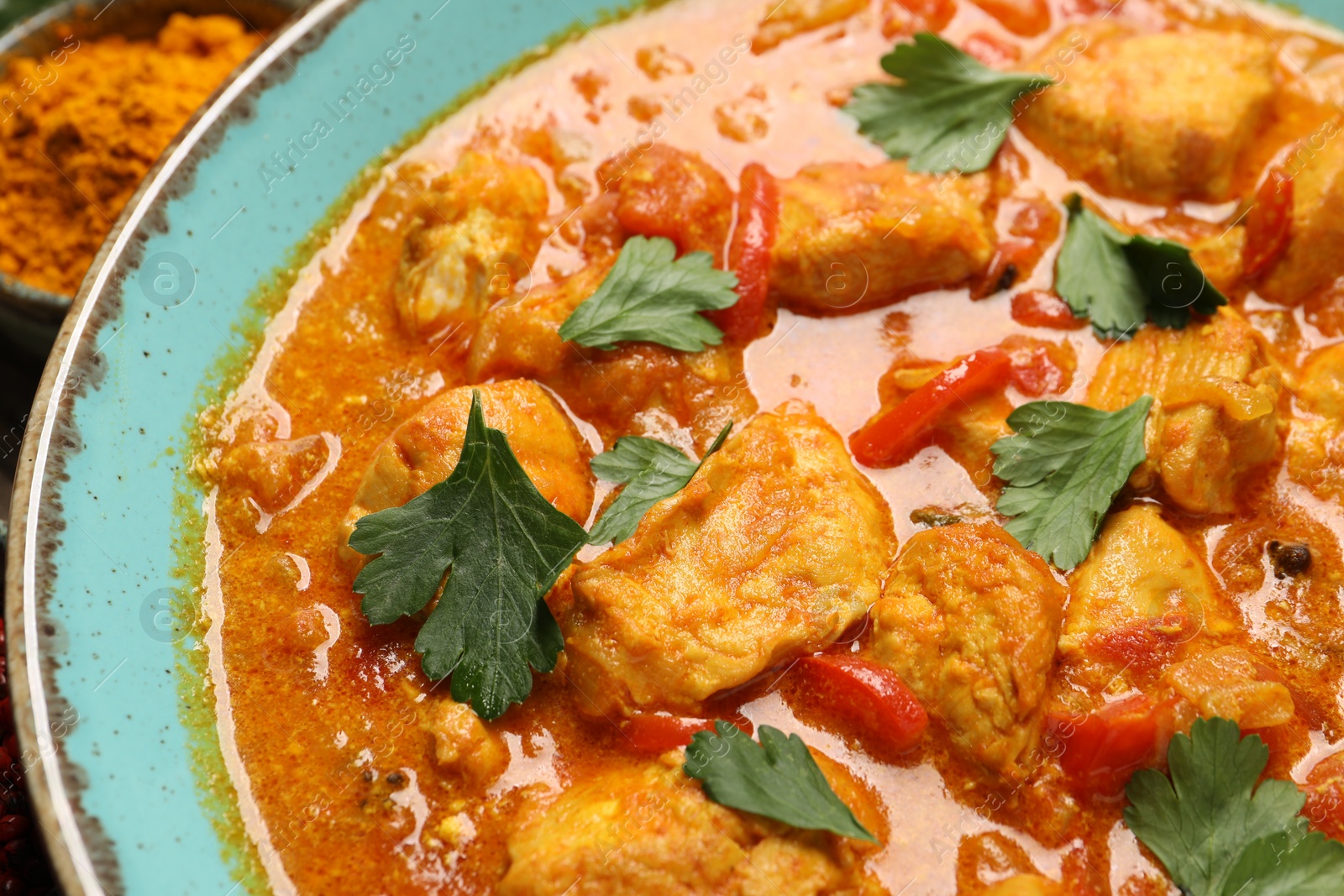 Photo of Delicious chicken curry with parsley on table, closeup