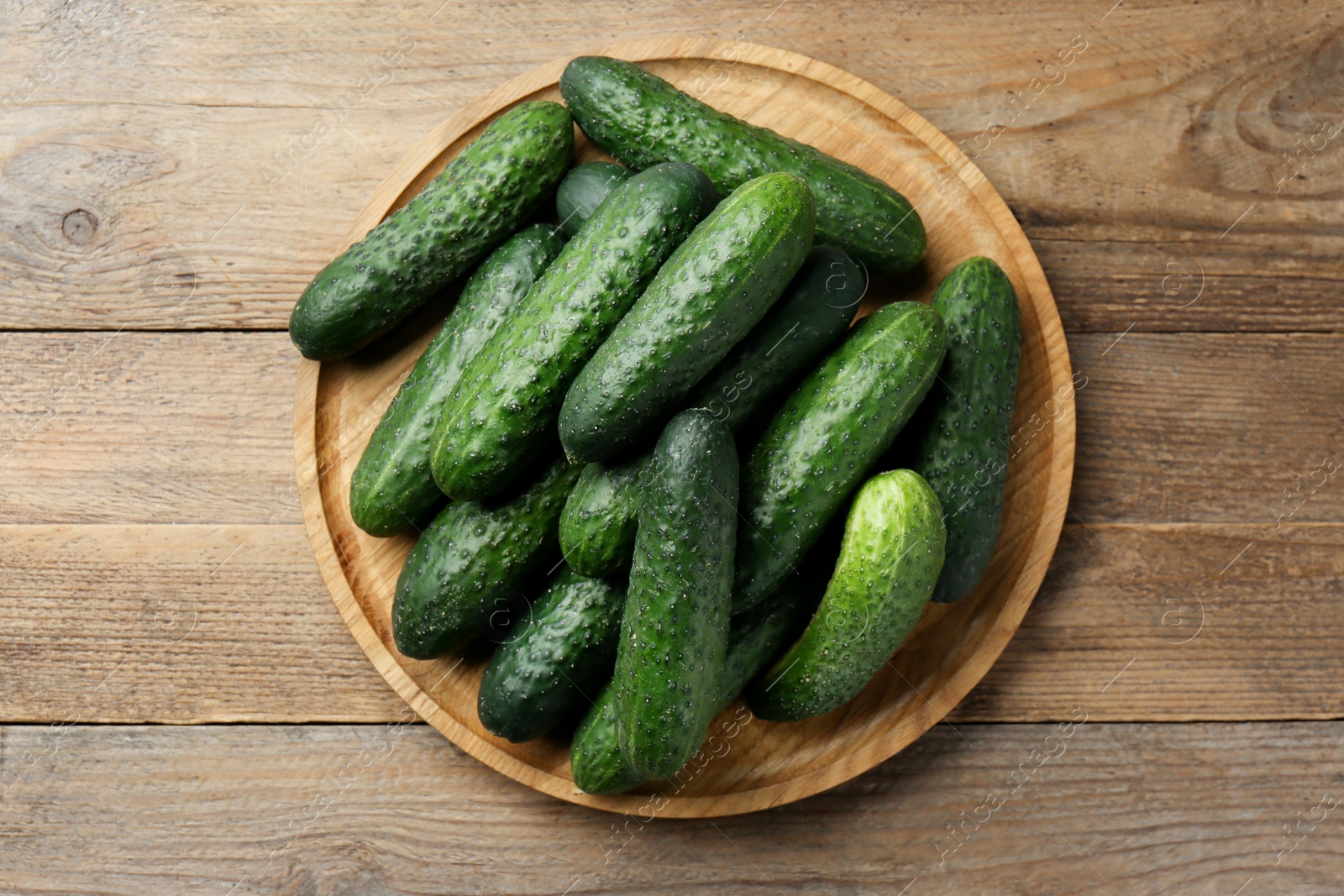 Photo of Fresh ripe cucumbers on wooden table, top view