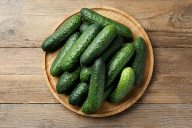 Photo of Fresh ripe cucumbers on wooden table, top view