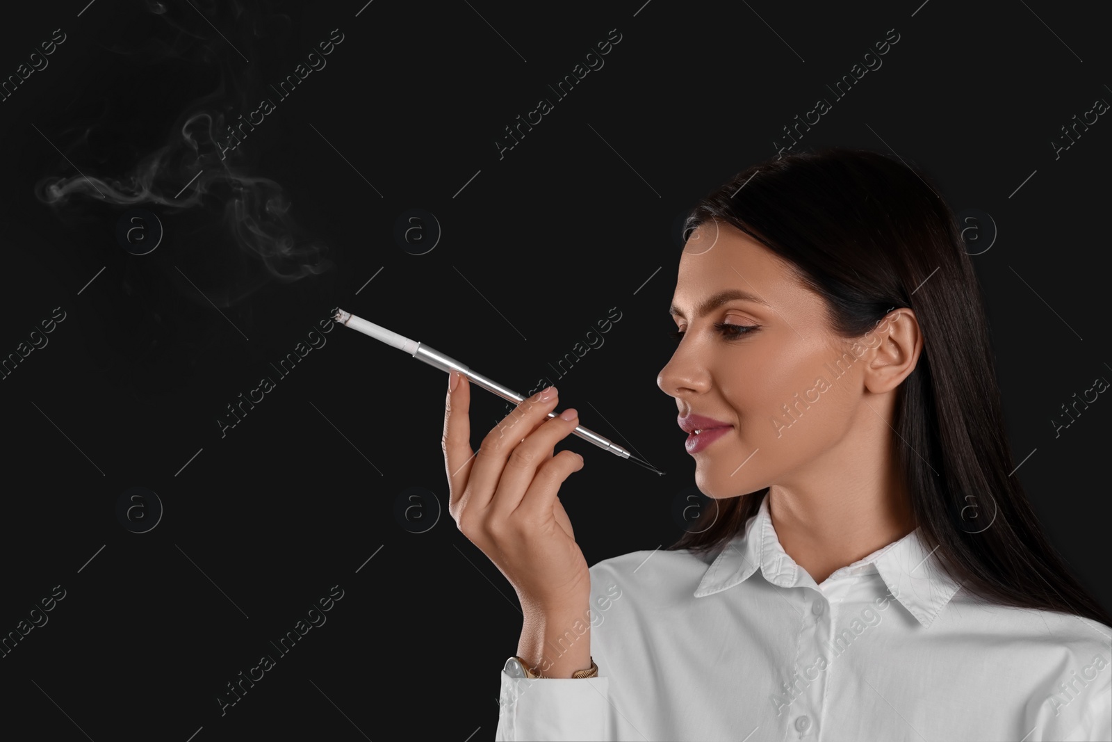 Photo of Woman using long cigarette holder for smoking on black background, space for text