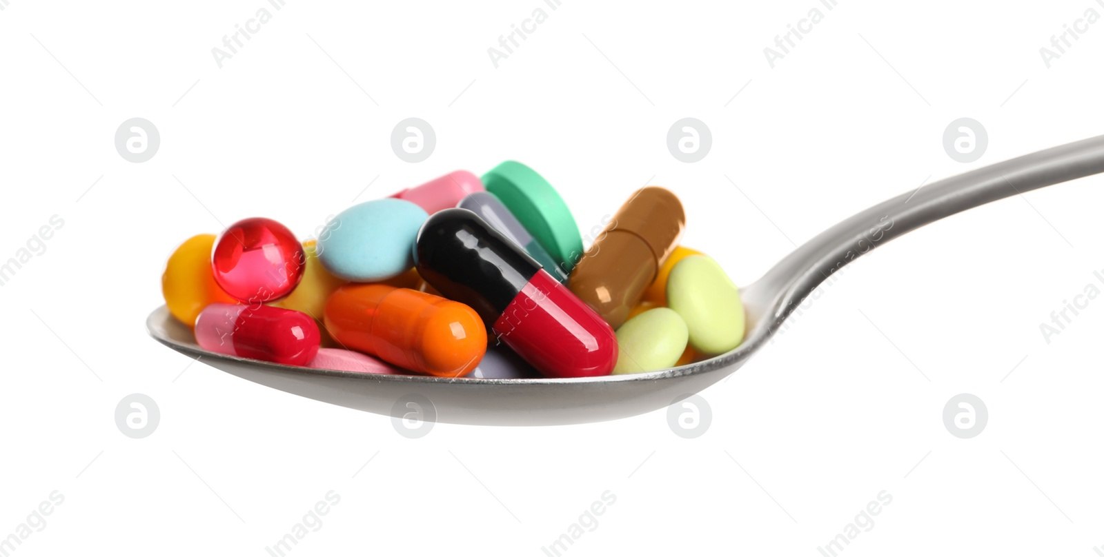 Photo of Spoon with different colorful pills on white background