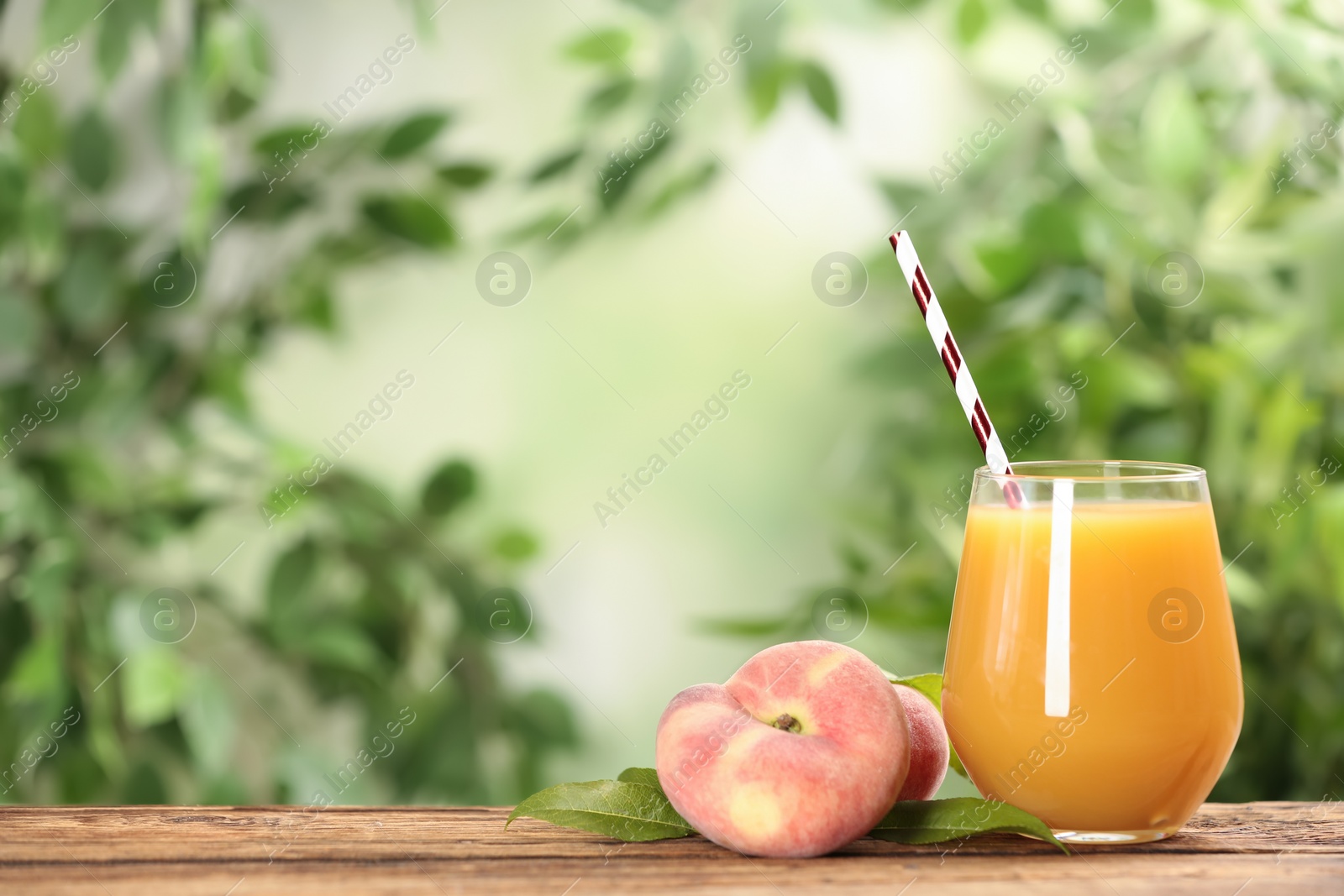 Photo of Natural peach juice and fresh fruits on wooden table. Space for text