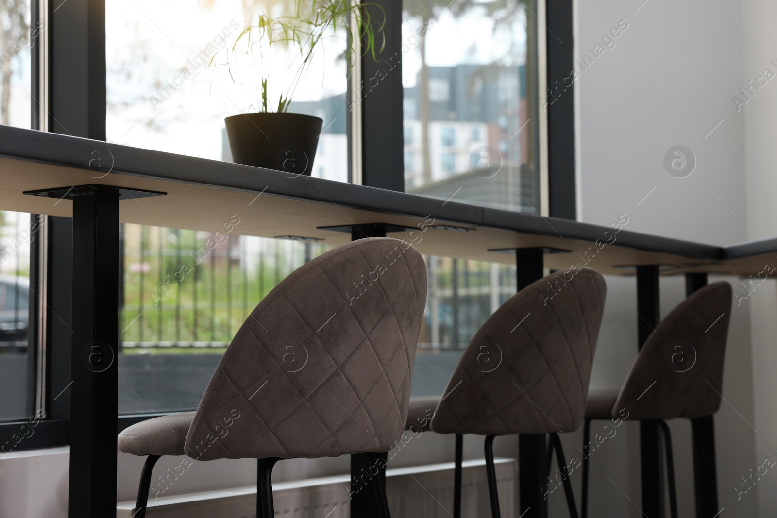 Photo of Table and bar stools near window in hostel dining room