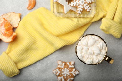 Flat lay composition with delicious marshmallow drink and yellow sweater on light grey table
