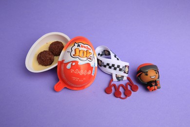 Photo of Sveti Vlas, Bulgaria - June 30, 2023: Kinder Joy Egg with sweet candies and toy on violet background