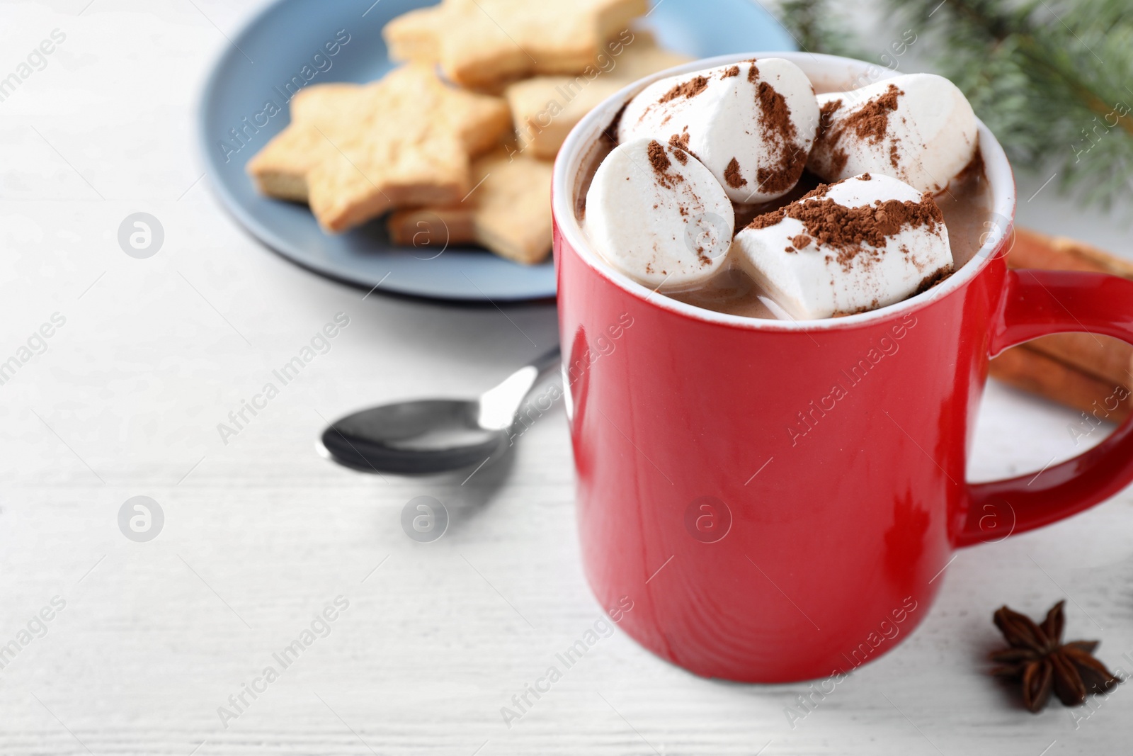 Photo of Composition of tasty cocoa with marshmallows in cup on white wooden table. Space for text