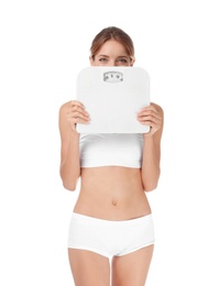 Happy slim woman satisfied with her diet results holding bathroom scales on white background