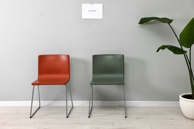 Chairs near grey wall in waiting area indoors