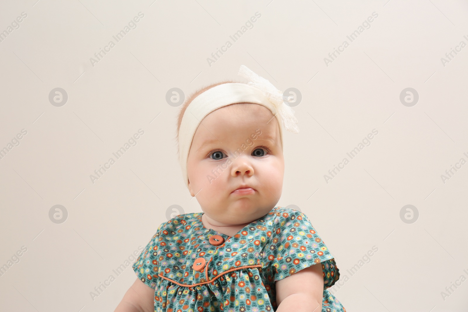 Photo of Little girl in cute dress on light background. Baby accessories