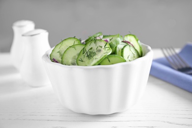 Photo of Bowl of tasty cucumber salad on table