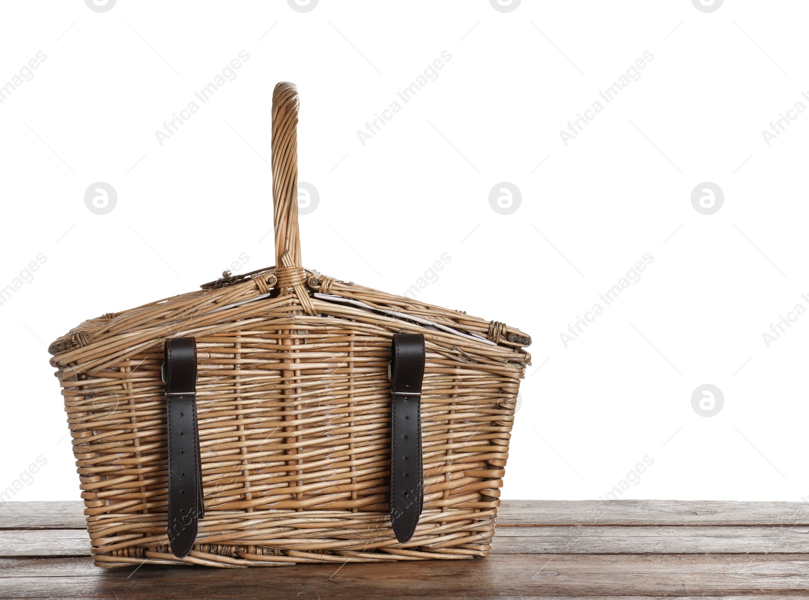 Photo of Closed wicker picnic basket on wooden table against white background