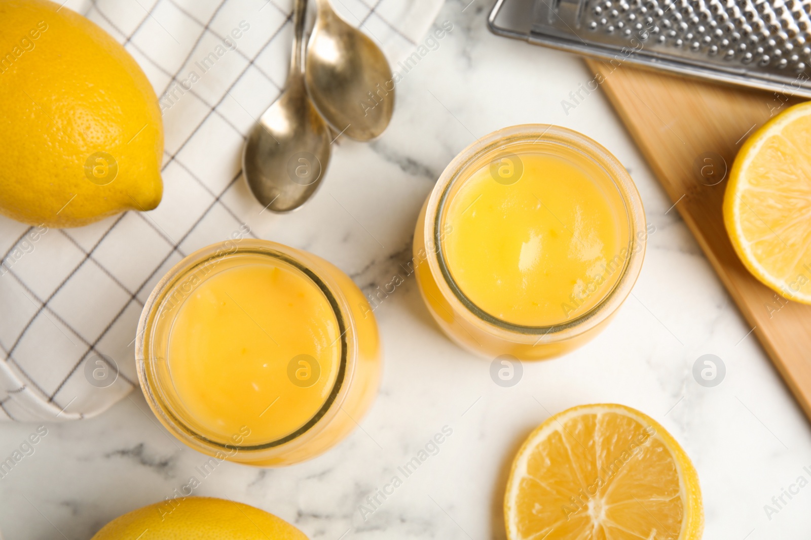 Photo of Delicious lemon curd and fresh fruits on white marble table, flat lay