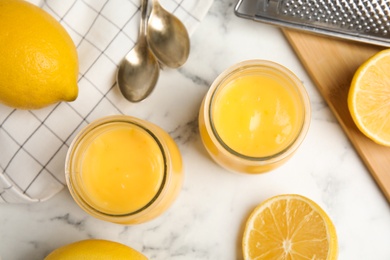 Delicious lemon curd and fresh fruits on white marble table, flat lay