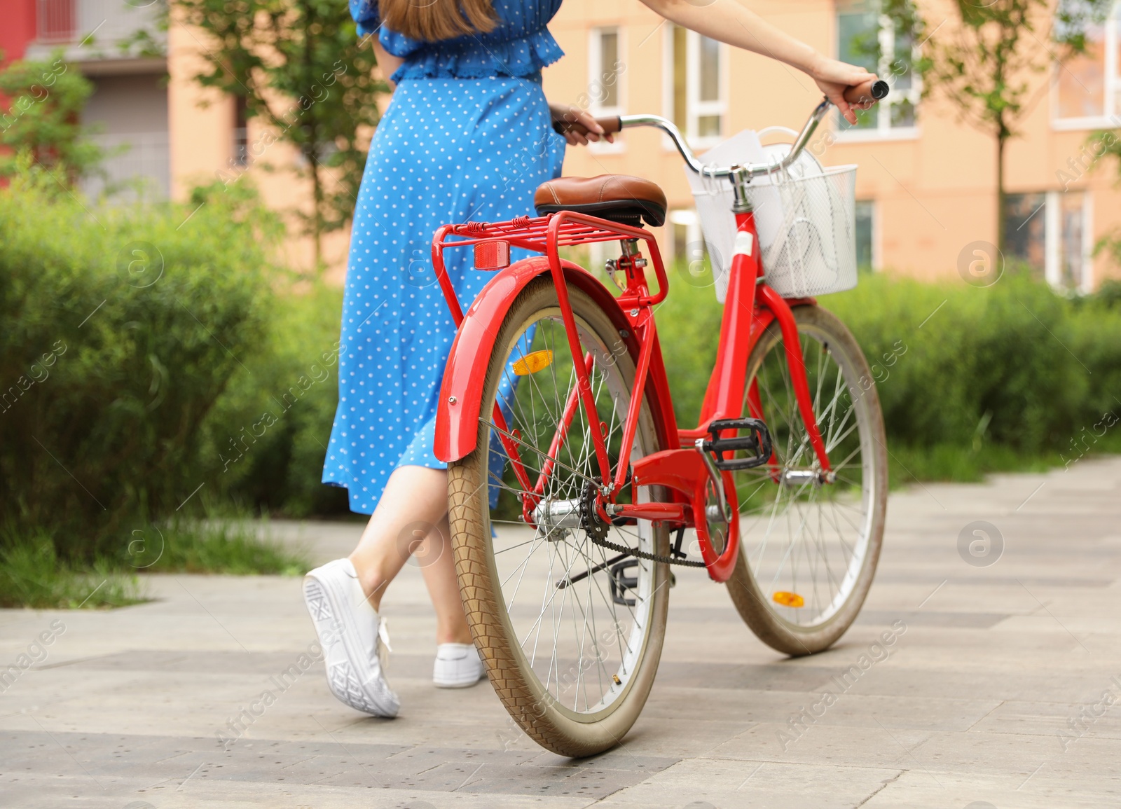 Photo of Young woman with bicycle in city, closeup