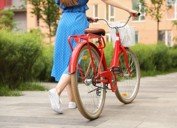 Young woman with bicycle in city, closeup