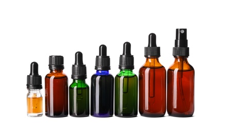 Photo of Cosmetic bottles of essential oils on white background