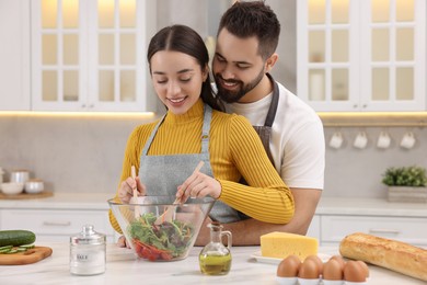 Photo of Lovely young couple cooking together in kitchen