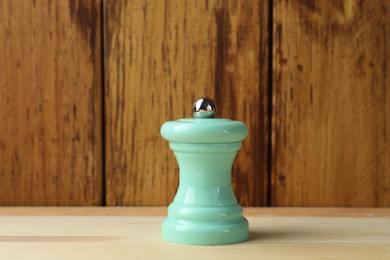 Photo of One turquoise shaker on light wooden table