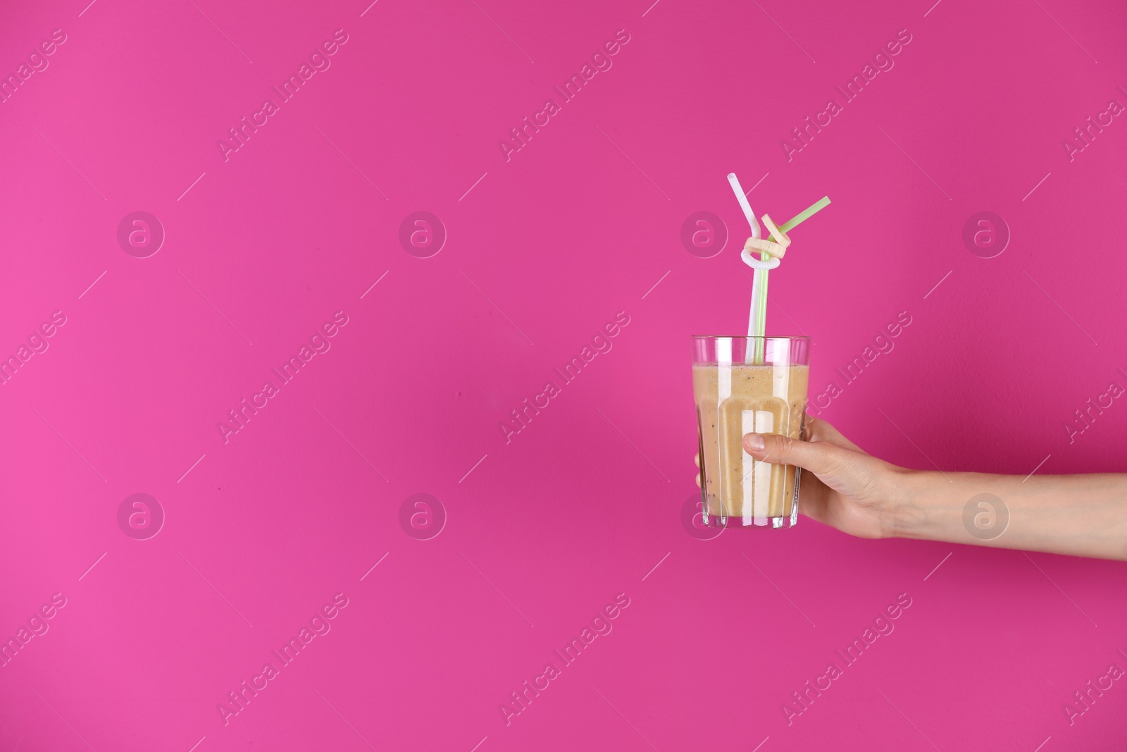 Photo of Young woman holding glass of healthy smoothie on color background