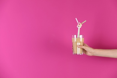 Young woman holding glass of healthy smoothie on color background