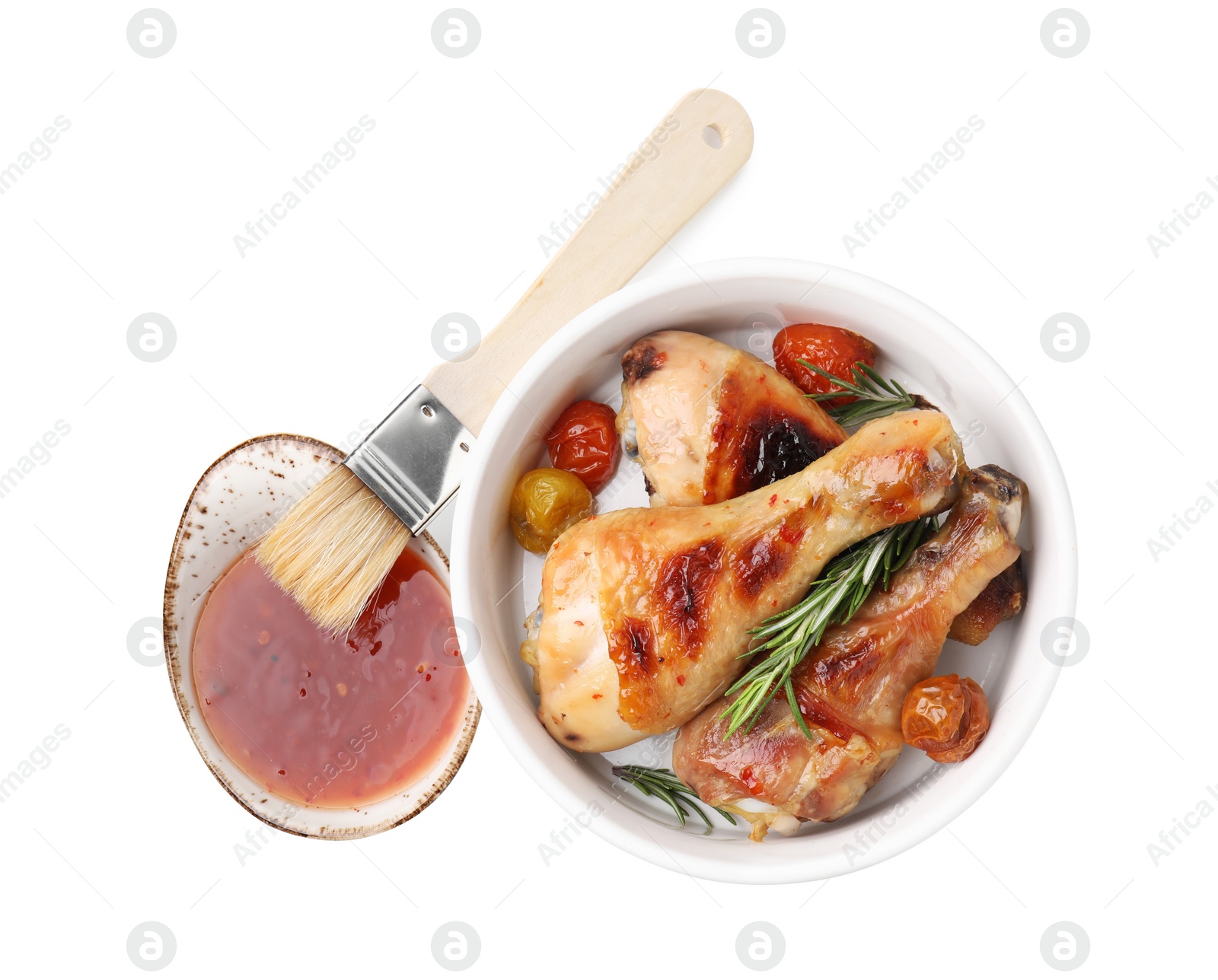 Photo of Marinade, basting brush, roasted chicken drumsticks, rosemary and tomatoes isolated on white, top view