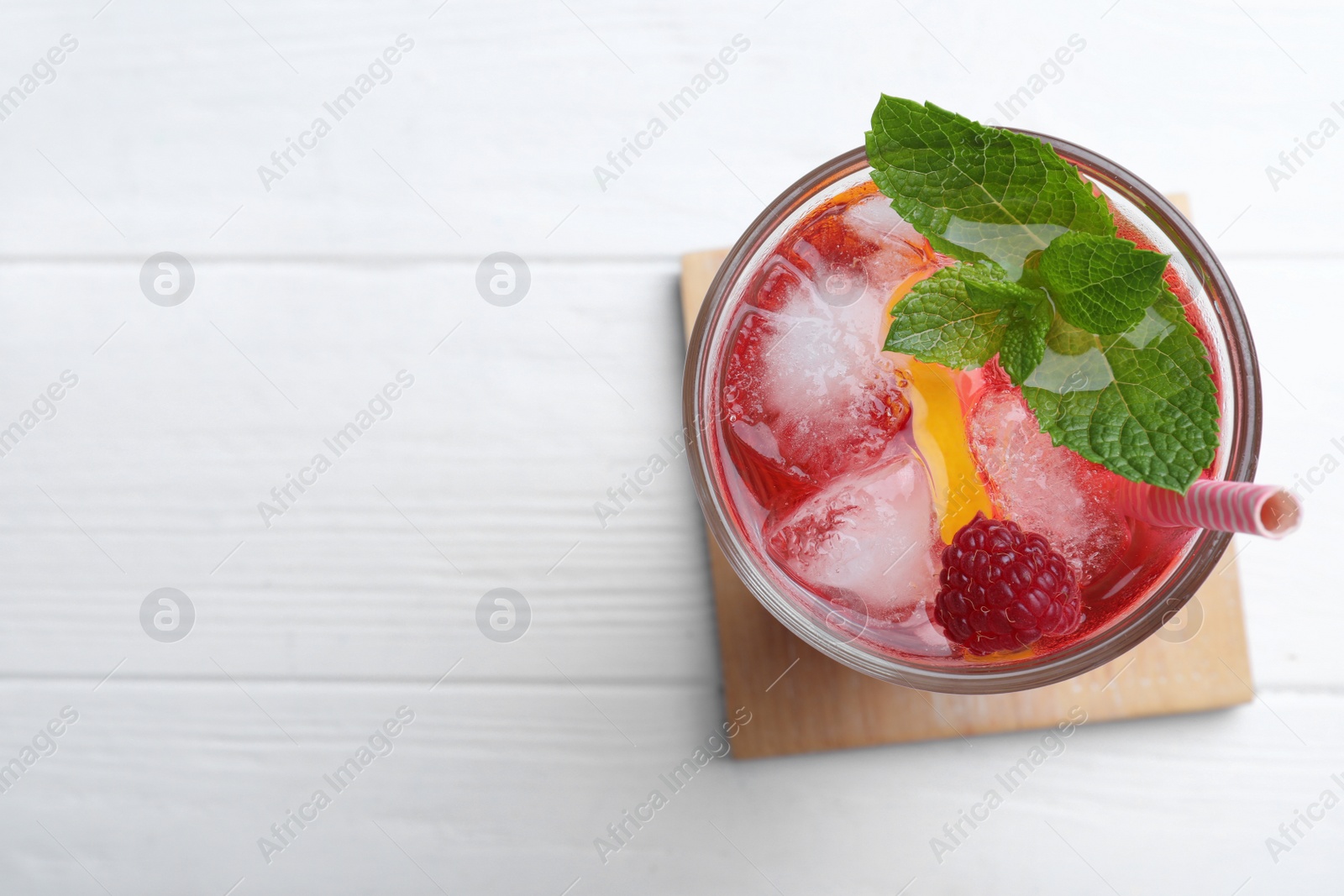 Photo of Delicious raspberry lemonade made with soda water on white wooden table, top view. Space for text