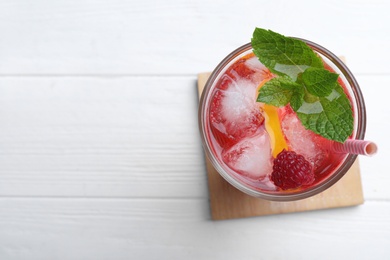 Photo of Delicious raspberry lemonade made with soda water on white wooden table, top view. Space for text