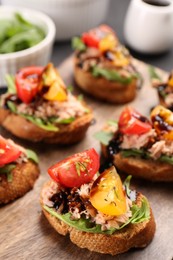 Photo of Delicious bruschettas with balsamic vinegar, tomatoes, arugula and tuna on table