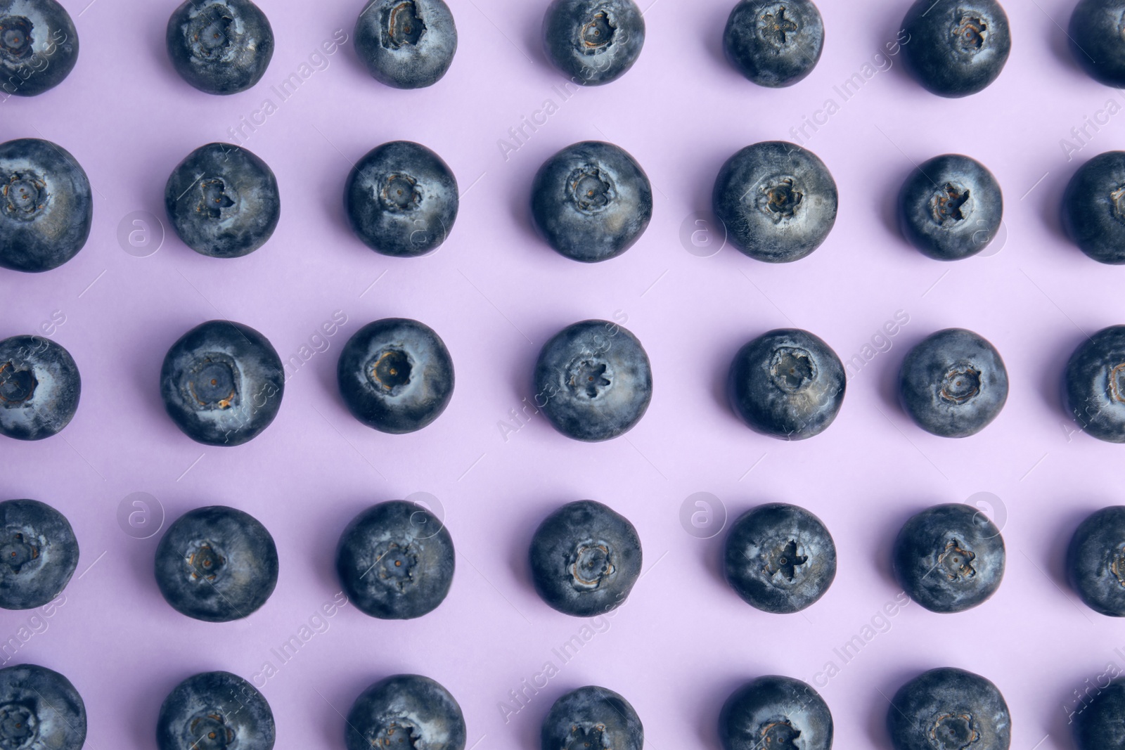 Photo of Fresh ripe blueberries on lilac background, flat lay