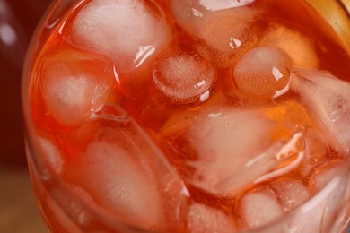 Photo of Aperol spritz cocktail and ice cubes in glass on table, closeup