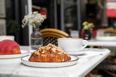 Photo of Delicious croissants on white marble table in cafe