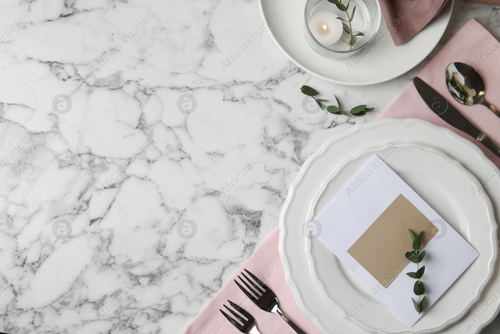 Photo of Elegant festive table setting with blank card on white marble background, flat lay. Space for text