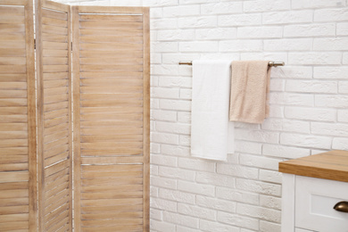 Photo of Fresh clean towels on hanger in bathroom