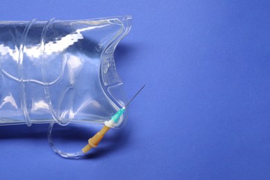 IV infusion set on blue background, top view. Space for text