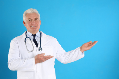 Portrait of senior doctor against blue background