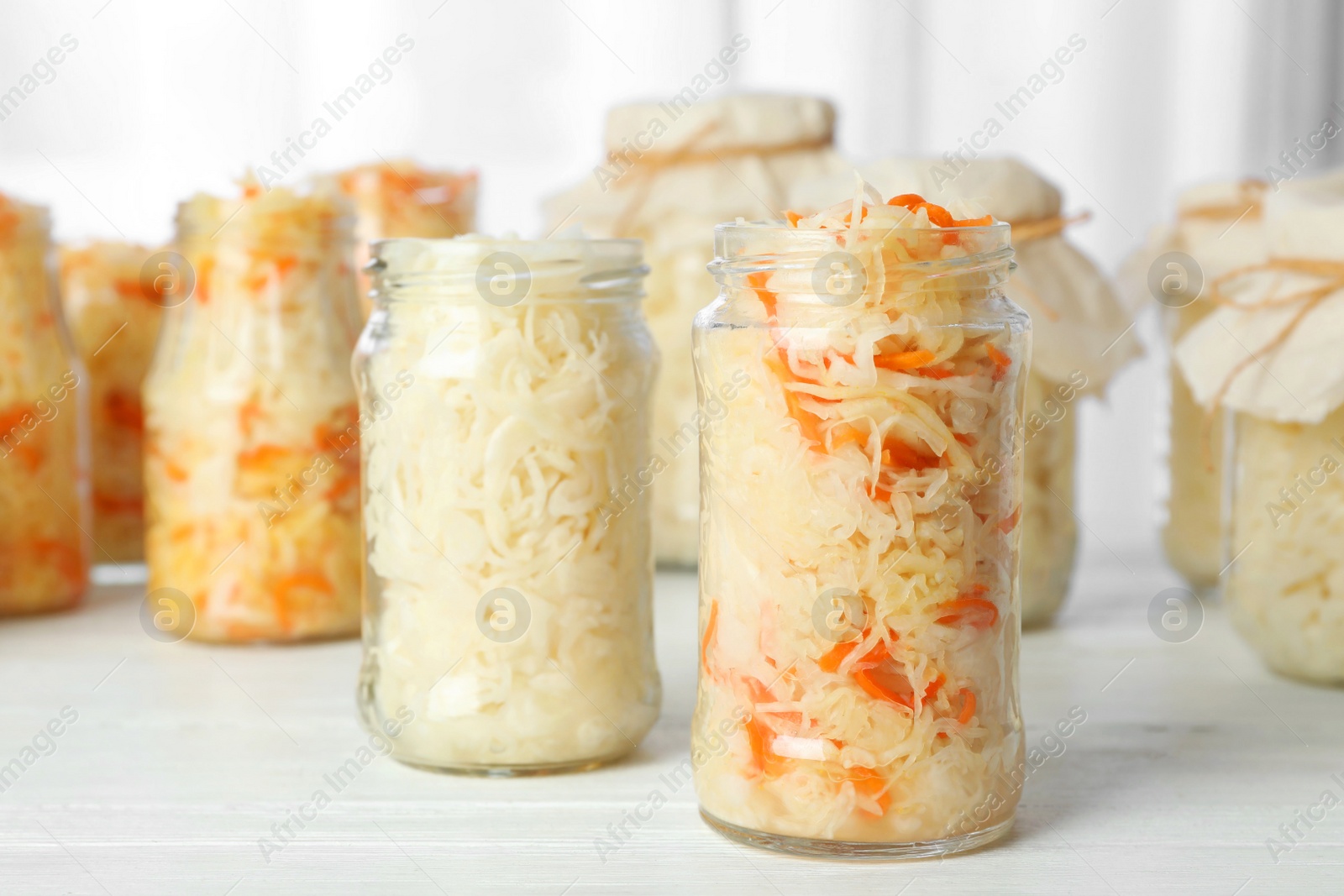 Photo of Tasty homemade fermented cabbage on white wooden table