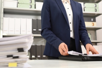 Photo of Woman working with documents at table in office, closeup