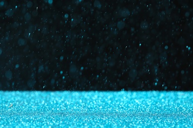 Photo of Glitter on table against dark background, space for text. Bokeh effect