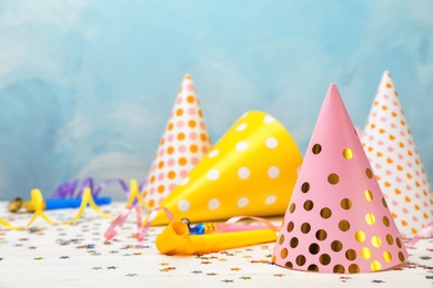 Photo of Birthday party caps on table against color background