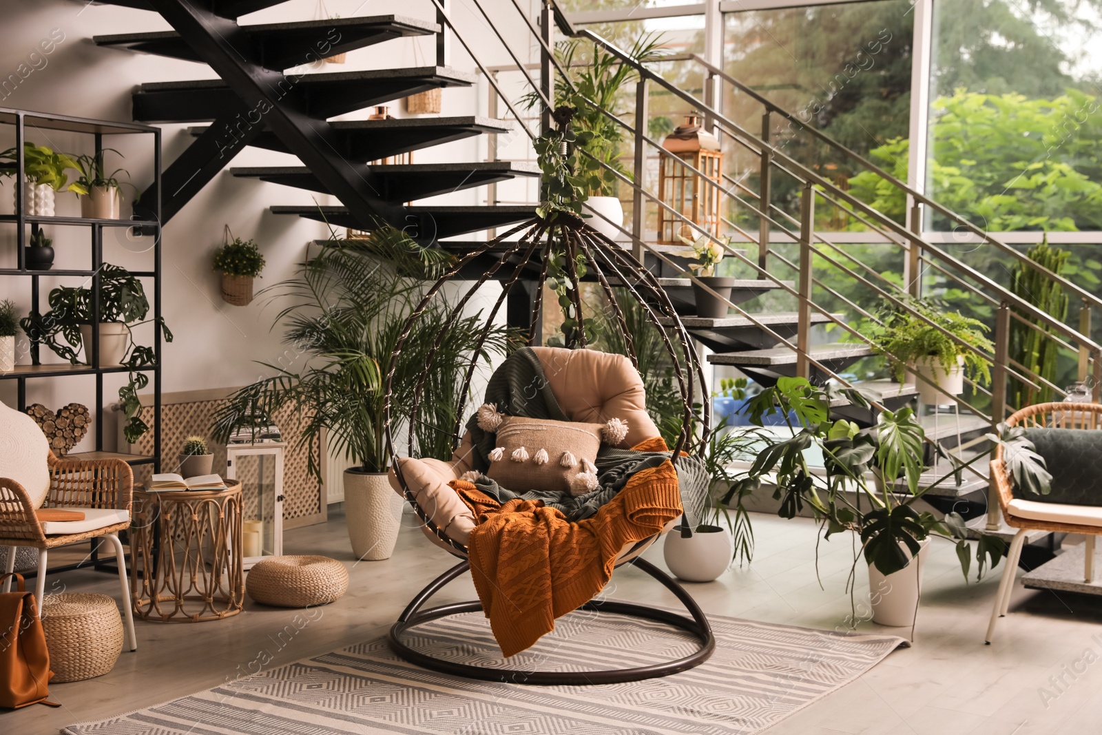 Photo of Indoor terrace interior with hanging chair and green plants