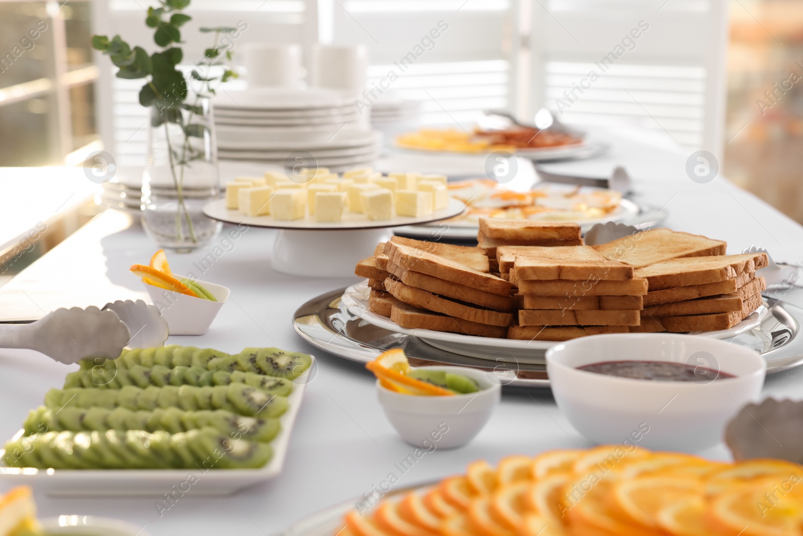 Photo of Clean dishware and different meals for breakfast on white table indoors. Buffet service